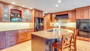 A kitchen with wooden cabinets, stainless steel appliances, and a central island. - Rhinelander Chain of Lakes Home w/ River Dock! (Rhinelander)