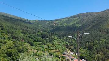 A rural landscape with a valley, houses, and a clear sky.