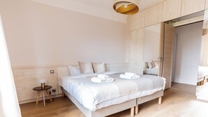 A modern bedroom with a large bed, a bedside table, and a mirror. - Le Cashmere - au centre de tout (Annecy)