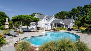A large house with a swimming pool, outdoor seating, and a garden. - Minutes from Downtown St. Michaels | Pool | Outdoor Kitchen | Private Dock | Hot (Easton)
