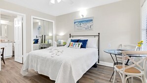 Una camera d'albergo con un letto, una scrivania, una sedia e un tavolino con fiori.