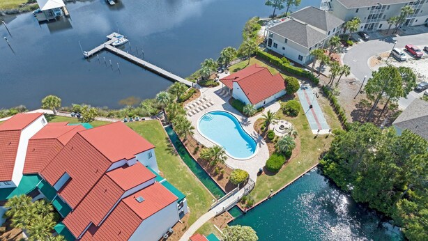 Una zona residenziale con piscina, un molo e un porto turistico.