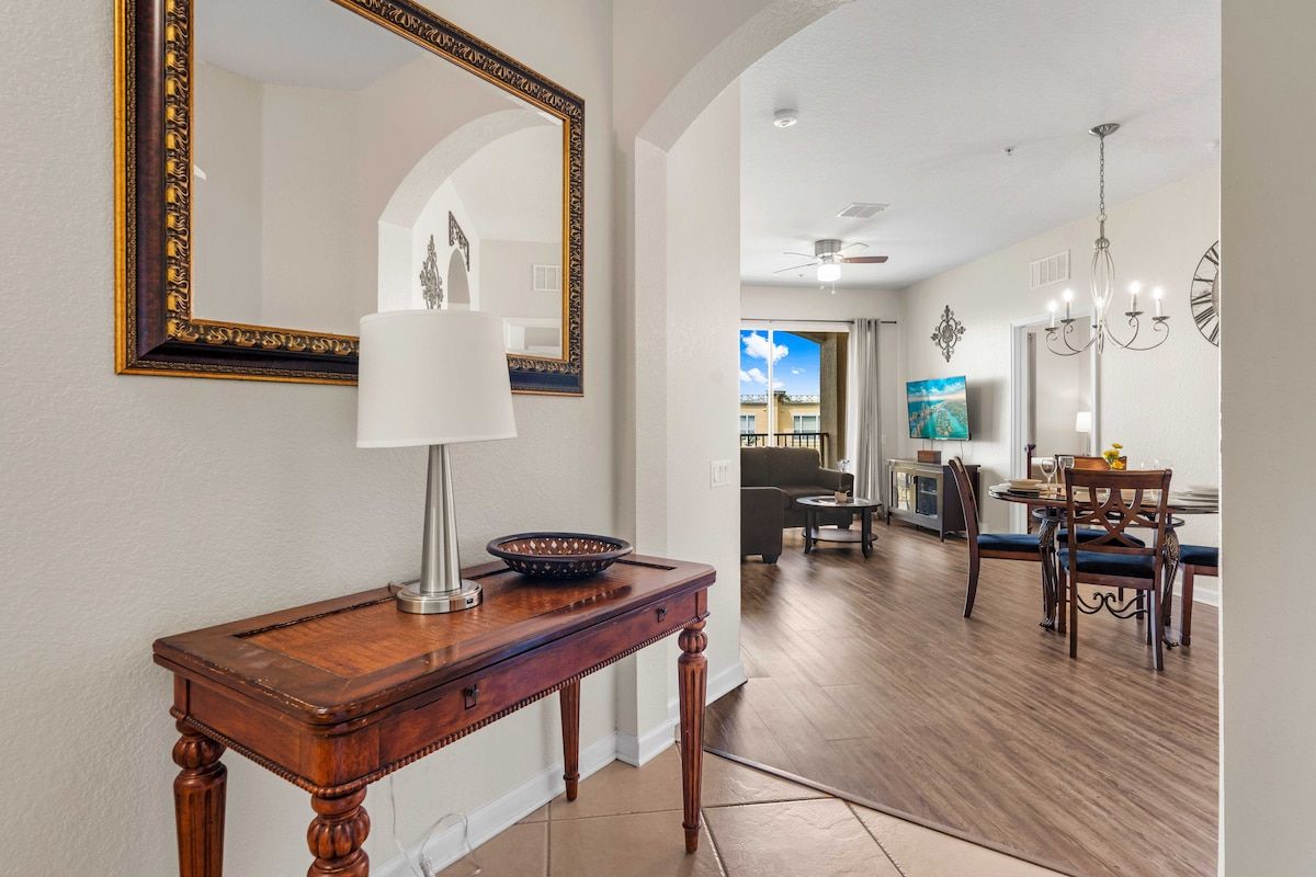 - An entrance with a stylish console table and elegant decor setting the tone for a cozy stay - Large mirror enhances the space leading into an open living and dining area - Arched doorways add a touch of charm as you enter the main living space