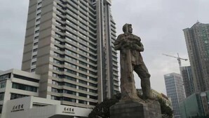 A statue in front of a tall building with multiple floors and windows. - Guangli Hotel (Haizhu Square) (Guangzhou)