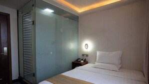 A hotel room with a bed, bedside table, and a glass partition wall. - Guangli Hotel (Haizhu Square) (Guangzhou)