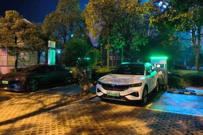 Un estacionamiento con un coche blanco y un coche negro.