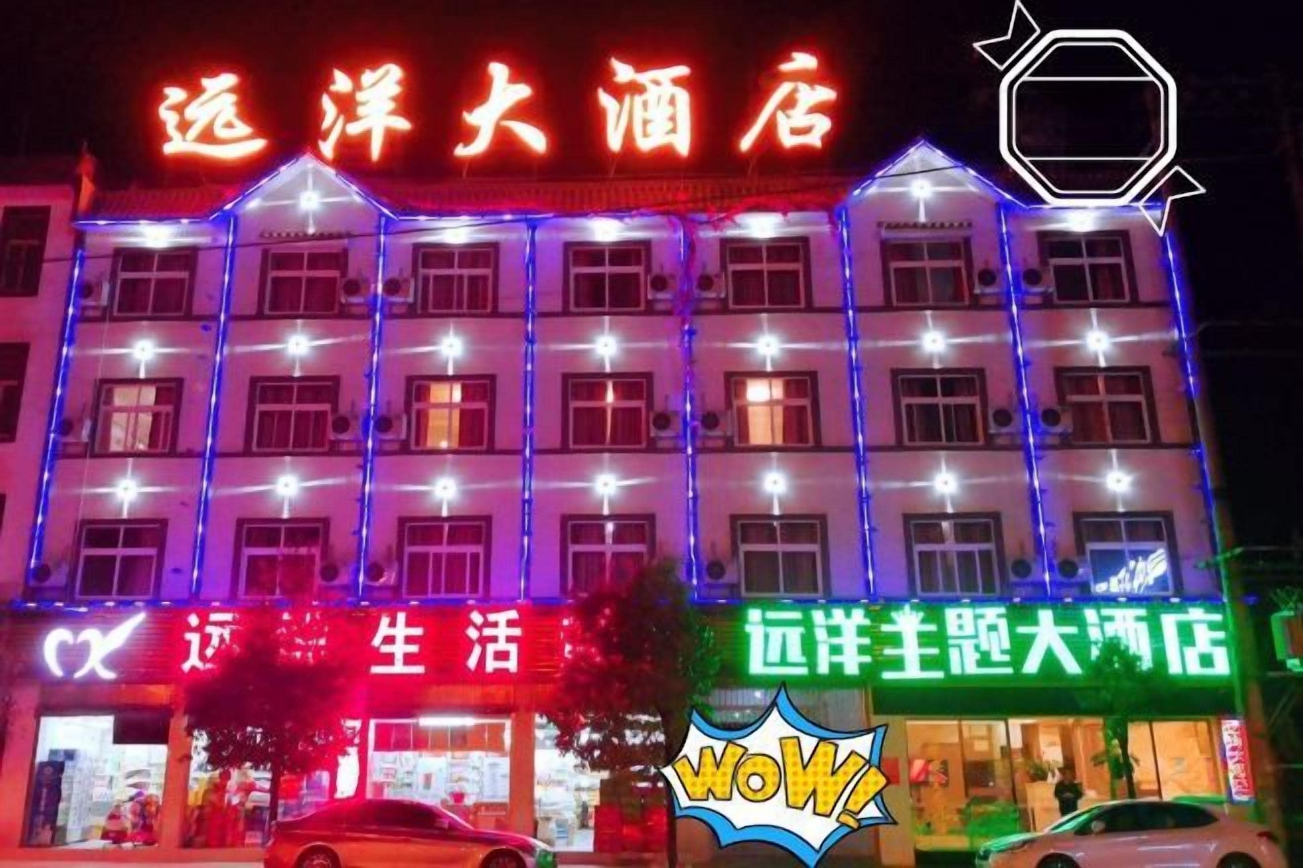 A hotel facade with illuminated signage and multiple windows.
