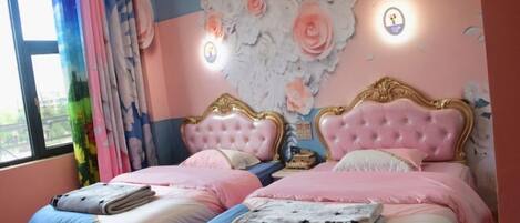 Camera da letto con due letti, ognuno con testiera rosa e biancheria da letto coordinata.
