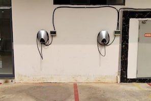 Two wall-mounted devices, possibly security or intercom systems, connected by a cable. - Longling Ocean Theme Hotel (Longling)