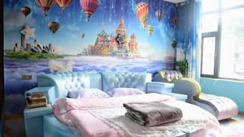 A bedroom with a mural of a city skyline and hot air balloons, a tufted headboard, and a bedside table with a lamp.