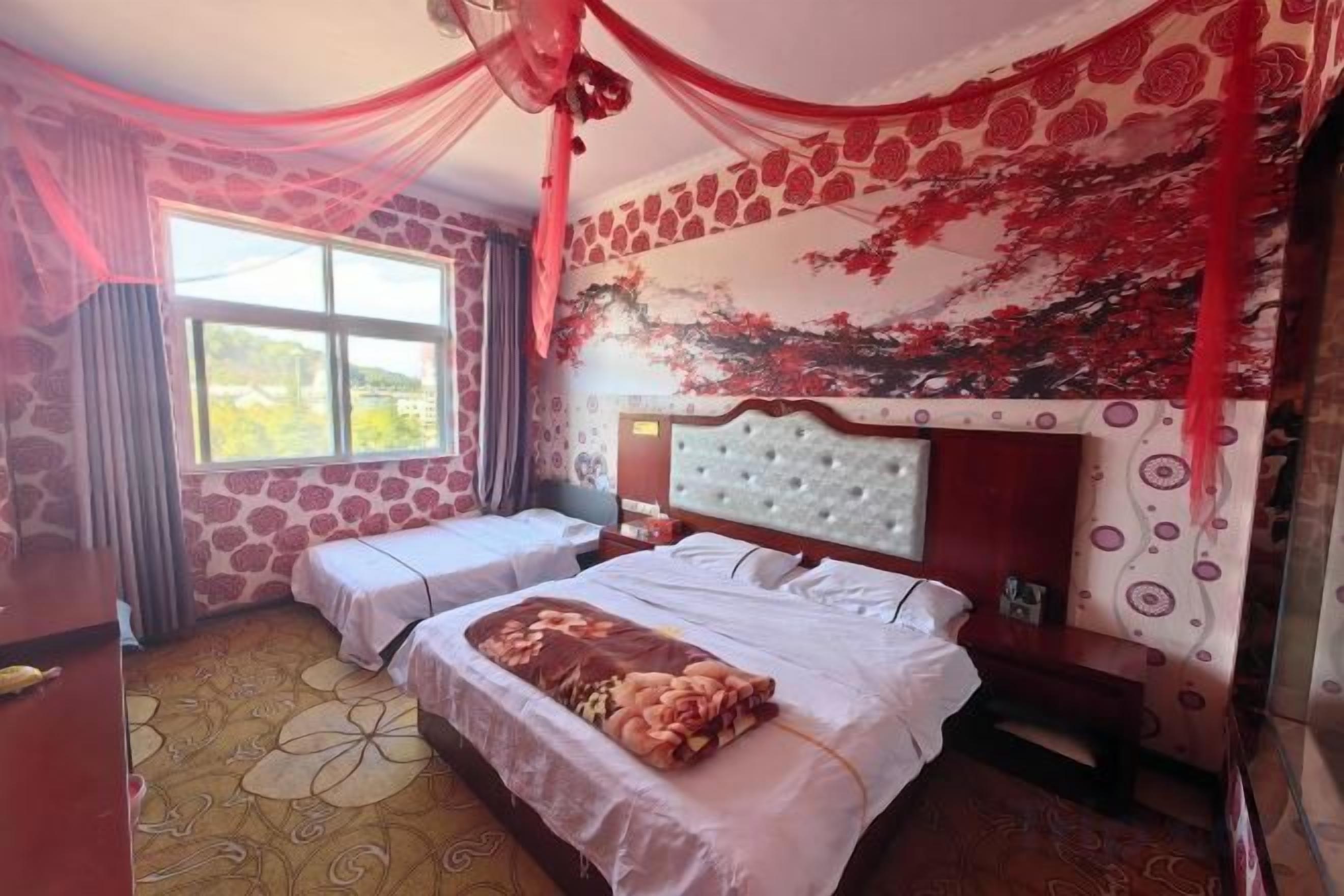 A bedroom with a bed, a bench, a window, and a decorative wall.