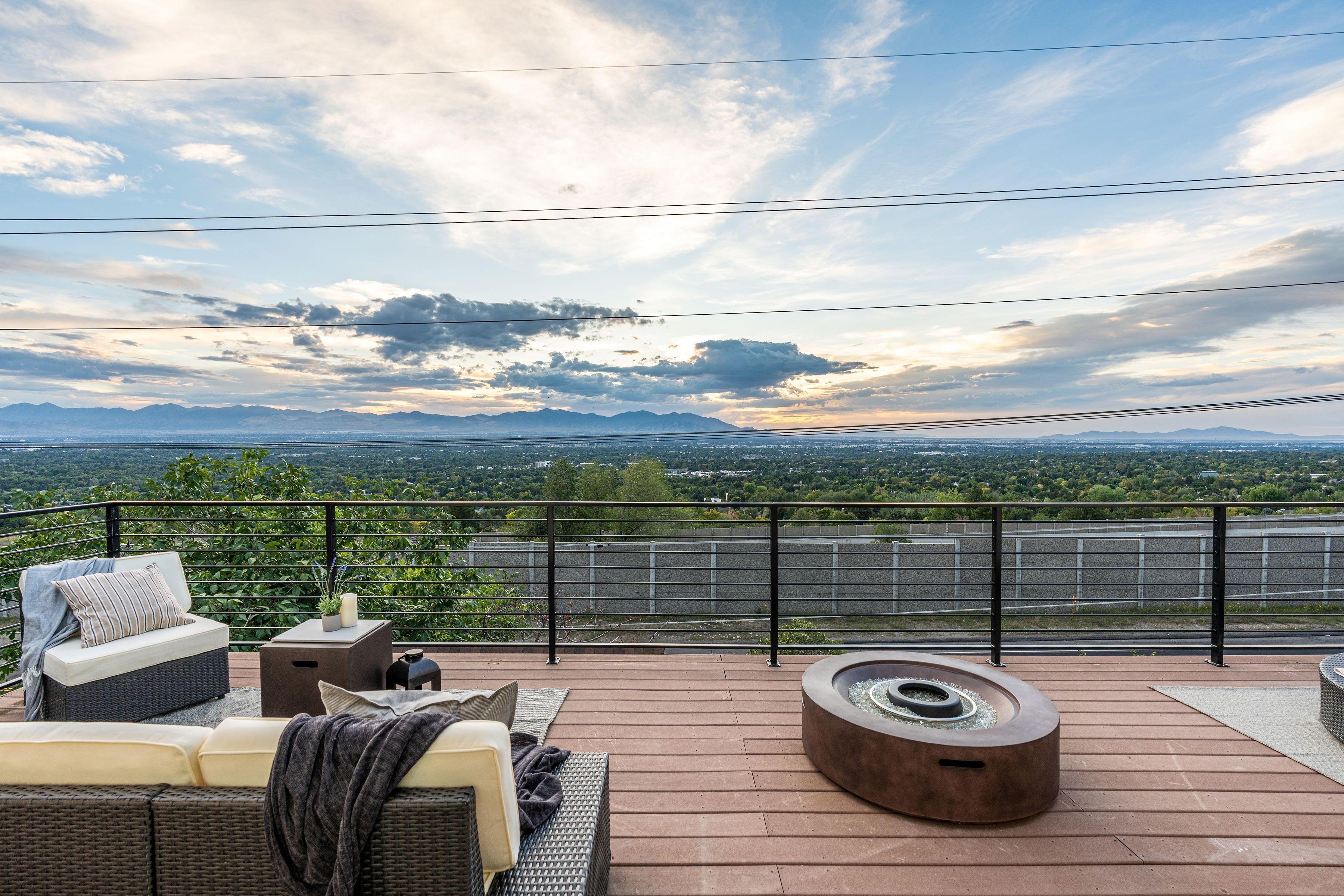 Une terrasse sur le toit avec des sièges extérieurs, un foyer et une vue sur les montagnes lointaines.
