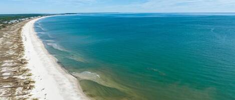 A coastal beach with clear water and a sandy shoreline.