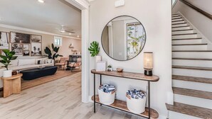 A modern living room with a sofa, coffee table, and a round mirror above a console table with storage baskets. - Port St Joe Beach House Pool 5BR Sleeps 12 by RedAwning (Port St. Joe)