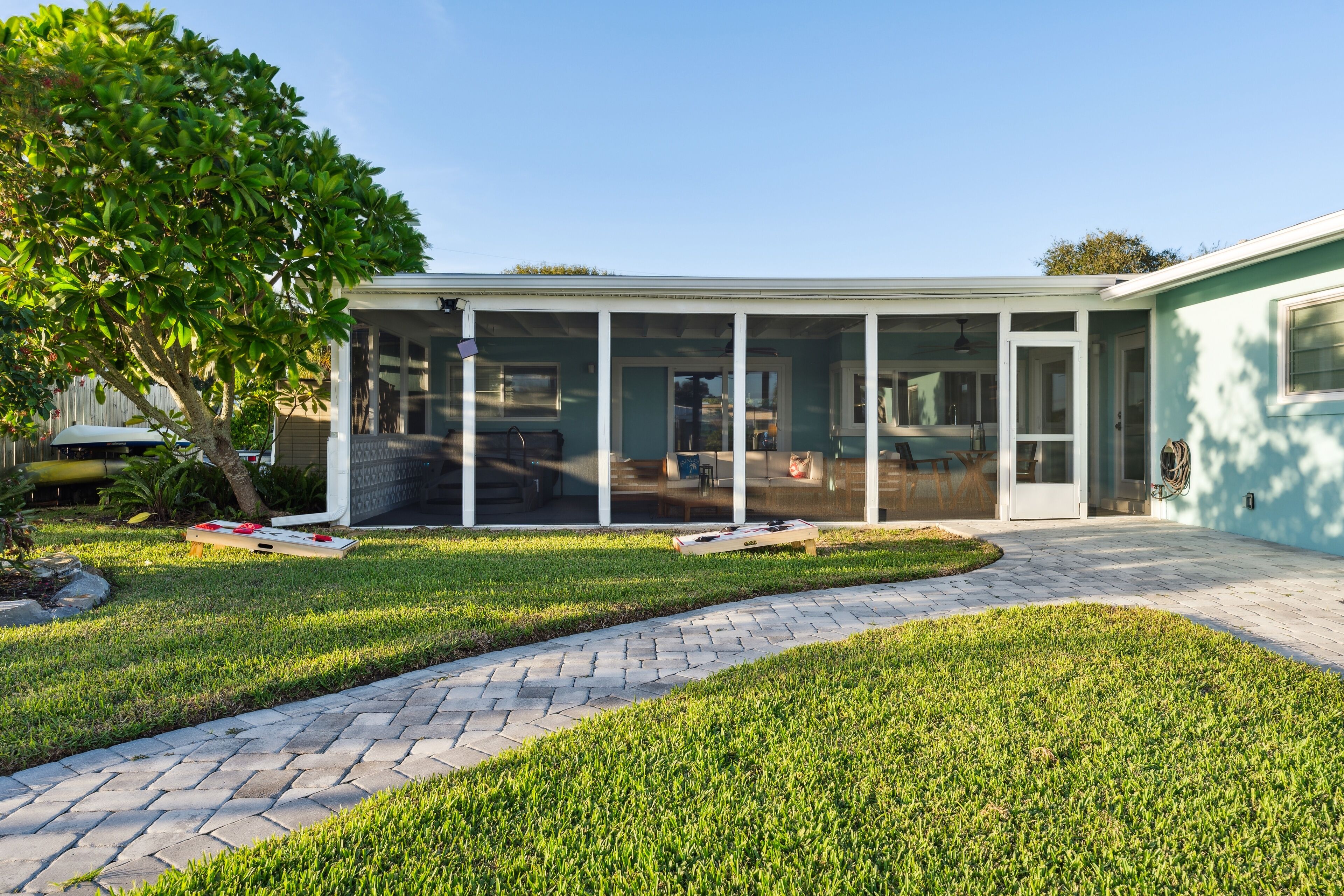 A modern house with a covered patio, a paved driveway, and a well-maintained lawn.