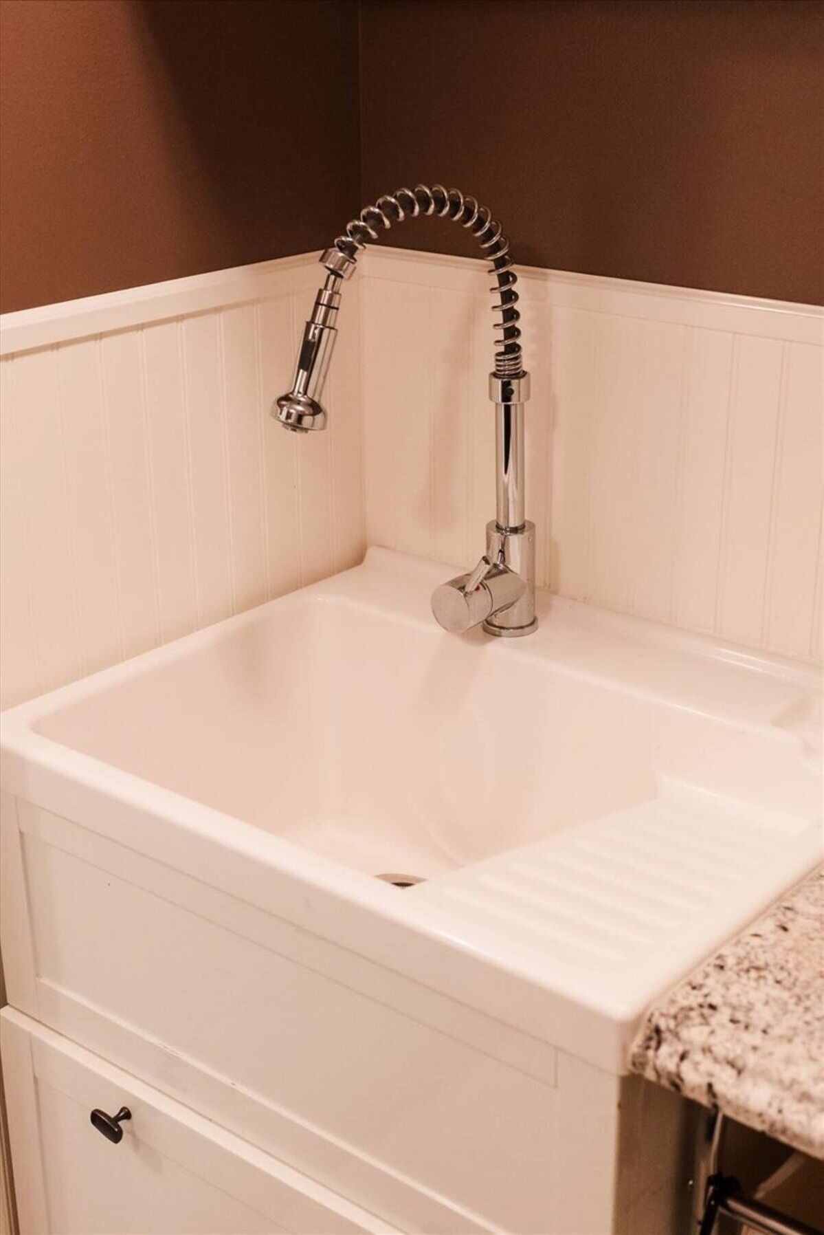 Un lavabo de salle de bain blanc, doté d’un robinet chromé et d’un plan de toilette blanc.