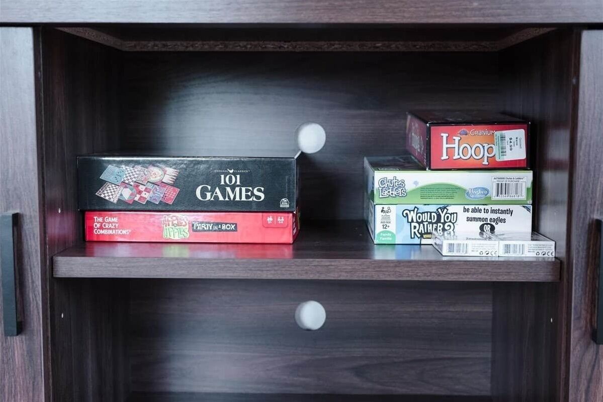 A wooden cabinet with two board games, '101 Games' and 'Would You Rather...'.