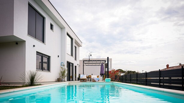 A modern house with a swimming pool, a covered patio, and a fenced garden area. - Modern Villa Noel with swimming pool (Valica)
