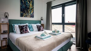 A hotel room with a large bed, a view of the beach, and a painting on the wall. - Modern Villa Noel with swimming pool (Valica)