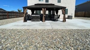 A covered patio area with outdoor furniture, a pergola, and a house in the background. - 5BR Home Hard Rock Casino & Beale AFB Area (Marysville)