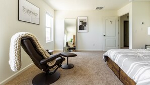 A bedroom with a bed, a massage chair, a large mirror, and artwork on the walls. - 5BR Home Hard Rock Casino & Beale AFB Area (Marysville)