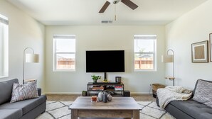 A living room with a flat-screen TV, two sofas, a coffee table, and a ceiling fan. - 5BR Home Hard Rock Casino & Beale AFB Area (Marysville)