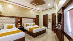 A hotel room with two beds, a ceiling fan, and a TV. - Hotel Imperial (Mumbai)