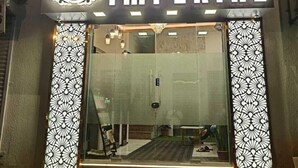The entrance of Hotel Imperial with a modern design, including a decorative sign and patterned pillars. - Hotel Imperial (Mumbai)