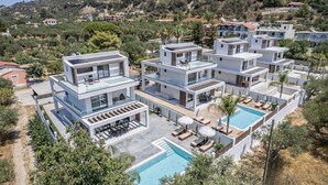 Ein modernes Resort mit mehreren Gebäuden, einem zentralen Pool und umgebender Bepflanzung.