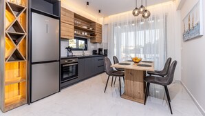 Eine moderne Küche mit integriertem Kühlschrank, Holzschränken und einem Essbereich mit Holztisch und -stühlen.