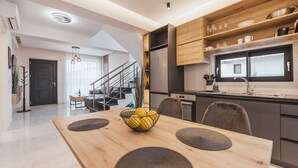 Eine moderne Küche mit Holzausstattung, einem eingebauten Backofen und einem großen Fenster.