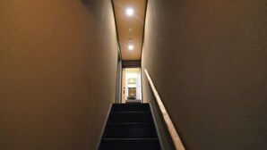 A narrow hallway with a staircase leading to a room. - Rinn Marikoji (Kyoto)