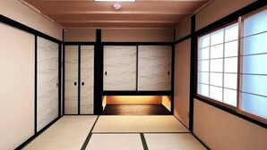 A traditional Japanese room with tatami flooring, sliding doors, and a low wooden platform. - Rinn Marikoji (Kyoto)