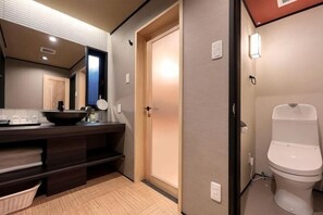 Een moderne badkamer met een wastafel, spiegel en toilet.