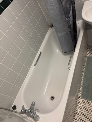 A bathroom with a bathtub, a shower, and a toilet.