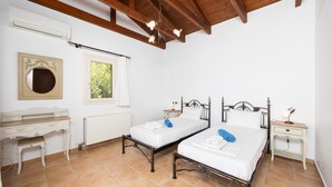 Un dormitorio con dos camas, un aparador, una ventana y un radiador.