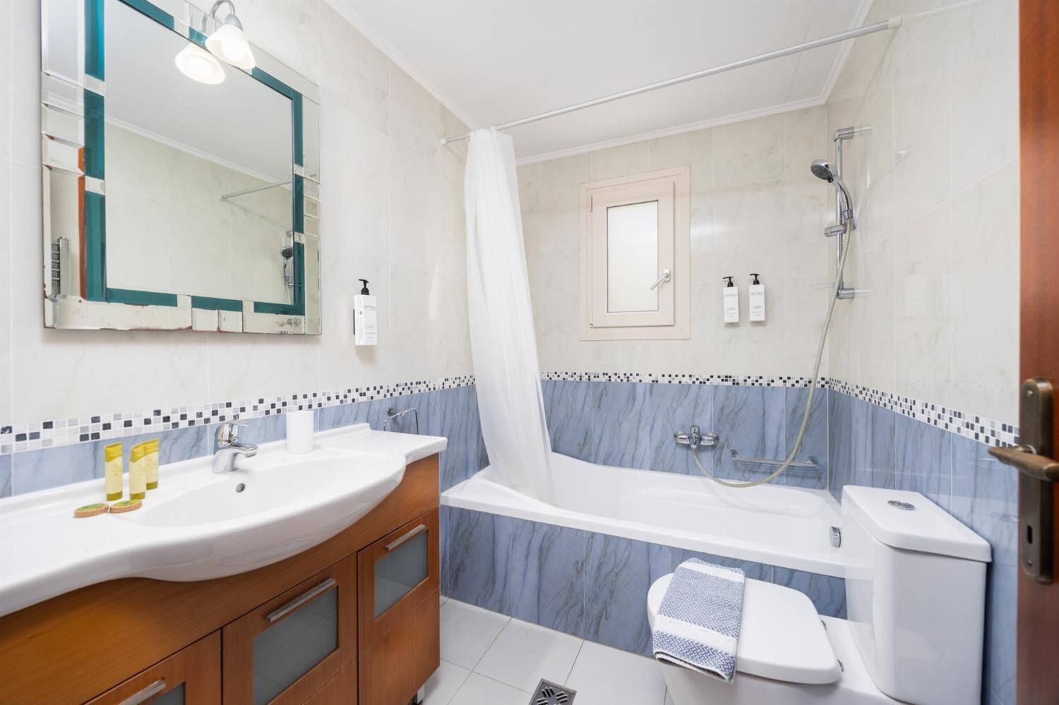 A bathroom with a sink, mirror, vanity, bathtub, shower, and toilet.