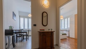 A modern living space with a dining area, a wooden cabinet, and a mirrored wall. - Casa Gabel by Wonderful Italy (Torino)