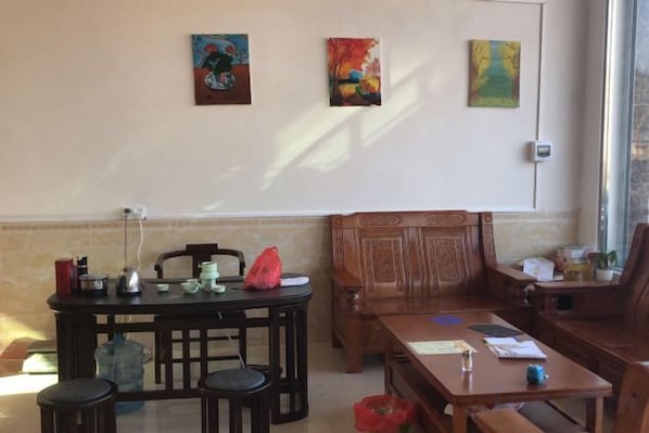 Una habitación con una mesa de comedor, sillas, un sofá y obras de arte en la pared.