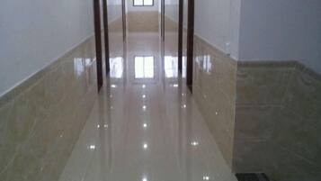 A hallway with a shiny floor, leading to a door at the end.