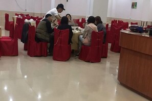 A conference room with round tables, red chairs, and a podium. - Holiday Inn Nanxiong Yongsen (Nanxiong)