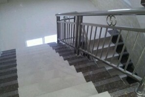 Eine Treppe mit Metallgeländern und einem gemusterten Teppich.