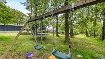 Relax in a serene park-like setting with a charming wooden swing set and communal seating area.