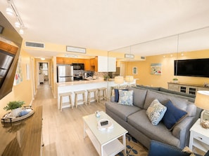 A modern living room with a sofa, coffee table, and a TV. - Jetty View at Jetty East! One FREE Beach Chair Setup Each Day of Your Stay! (Destin)