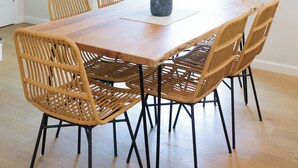 A dining area with a wooden table and six wicker chairs. - 5 Min to Downtown Warwick, Wineries, Breweries, Hikes, Shops, & Greenwood Lake! (Warwick)