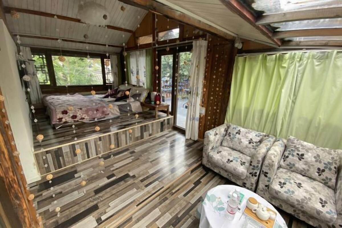A room with a bed, sofa, and a table with items on it.