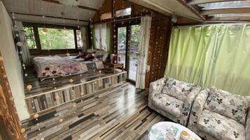 A room with a bed, sofa, and a table with items on it.