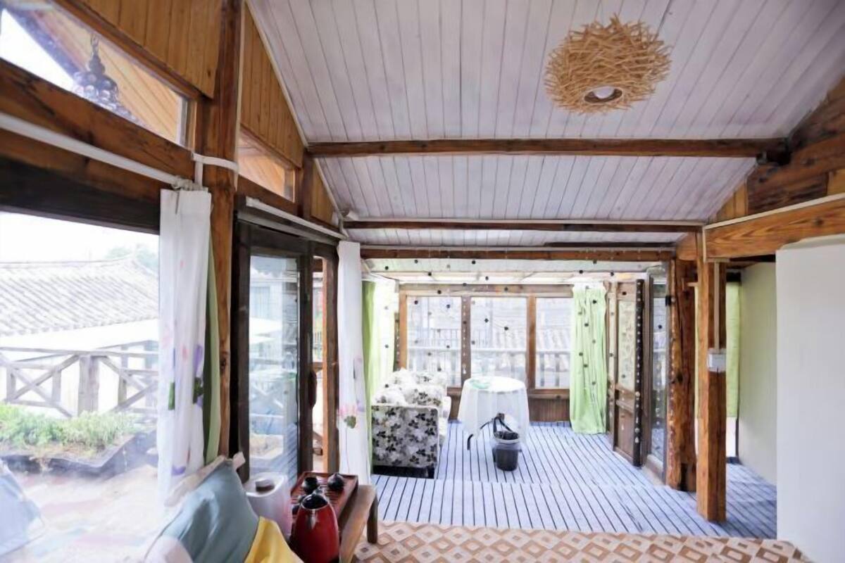 Un interior de madera con piso estampado, un sofá, una mesa y una lámpara colgante.