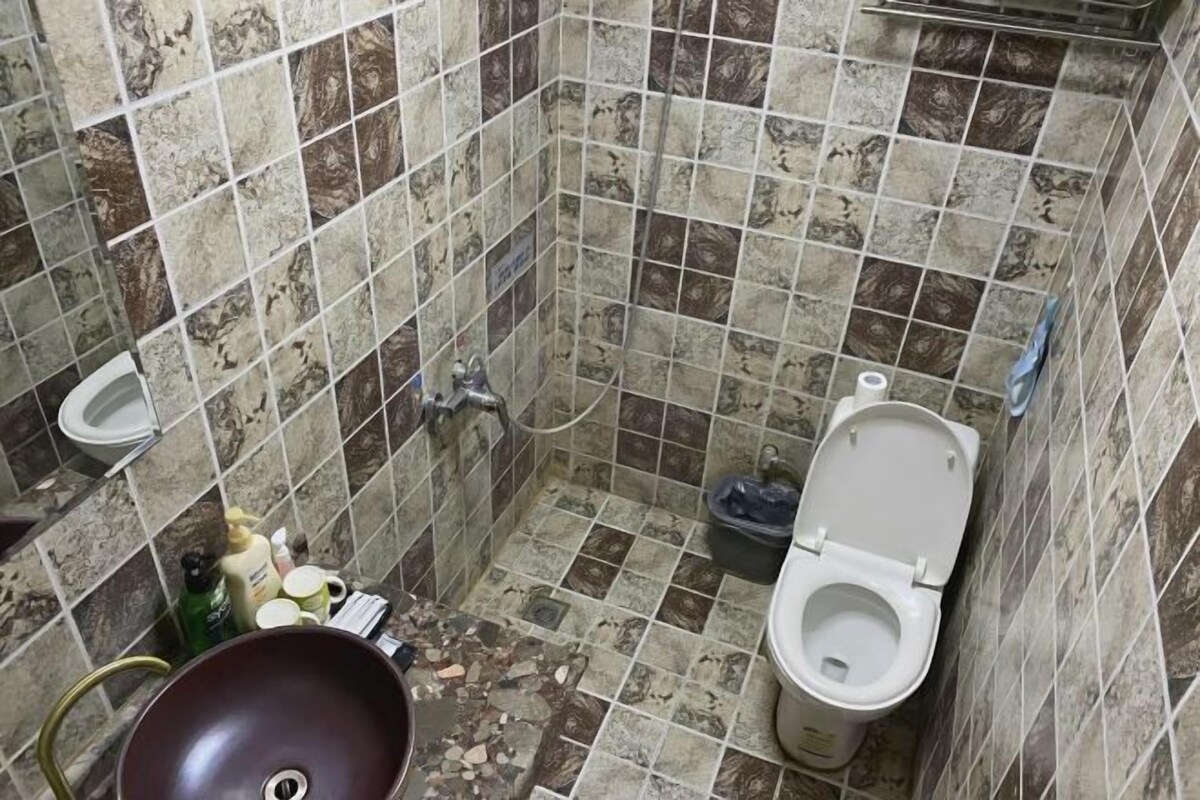 A small bathroom with a toilet, sink, and a large basin.