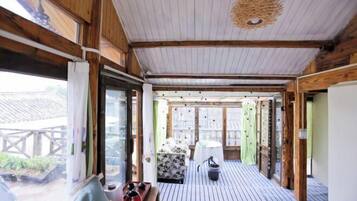 A wooden interior with a bed, a table, and a chair.